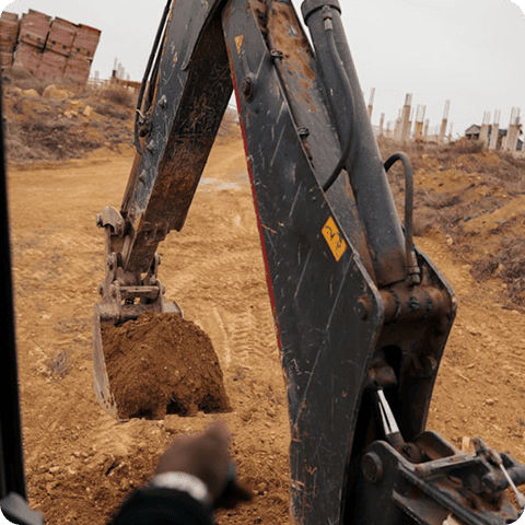 Excavator digging soil at a construction site, showcasing heavy machinery for earthmoving.