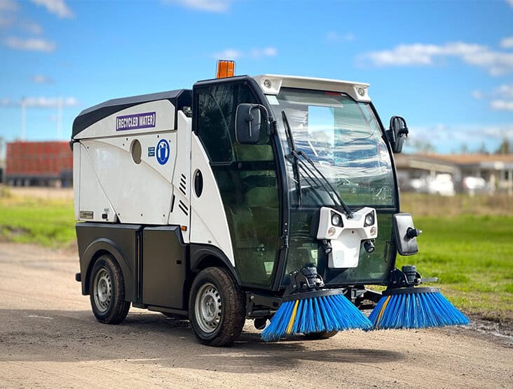 Urban street sweeper with dual brushes for efficient cleaning.