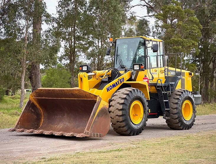 Heavy-duty Komatsu wheel loader in action on a construction site.